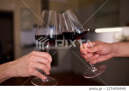A joyful celebration with wine glasses toasting, creating a delightful ambiance of togetherness A joyful celebration with wine glasses toasting, creating a delightful ambiance of togetherness 125409846