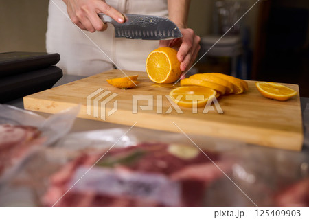 Slicing Fresh Oranges on a Beautiful Wooden Cutting Board to Enhance Your Culinary Skills Slicing Fresh Oranges on a Beautiful Wooden Cutting Board to Enhance Your Culinary Skills 125409903