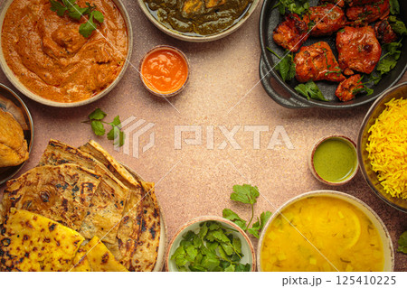 Traditional assorted Indian dishes arranged top view on beige background table. Cuisine of India, space for text 125410225