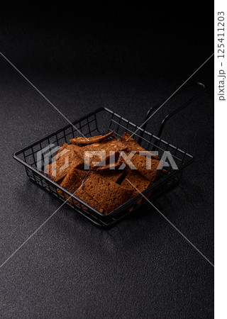 Crispy homemade brown bread chips with seeds and grains, salt, spices Crispy homemade brown bread chips with seeds and grains, salt, spices 125411203