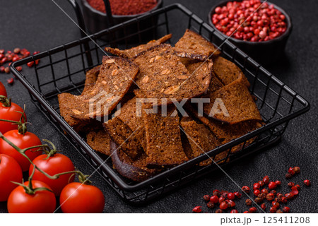 Crispy homemade brown bread chips with seeds and grains, salt, spices Crispy homemade brown bread chips with seeds and grains, salt, spices 125411208