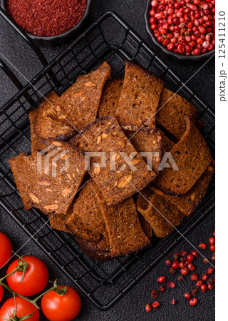 Crispy homemade brown bread chips with seeds and grains, salt, spices Crispy homemade brown bread chips with seeds and grains, salt, spices 125411210