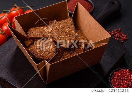 Crispy homemade brown bread chips with seeds and grains, salt, spices Crispy homemade brown bread chips with seeds and grains, salt, spices 125411238
