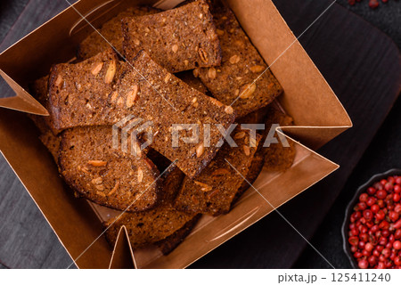 Crispy homemade brown bread chips with seeds and grains, salt, spices Crispy homemade brown bread chips with seeds and grains, salt, spices 125411240
