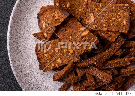 Crispy homemade brown bread crackers or croutons with seeds and grains 125411378