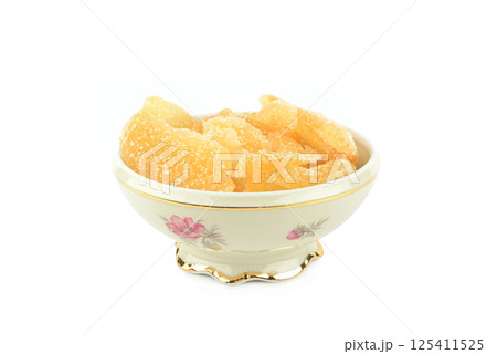 Candied ginger in a porcelain bowl isolated on white. 125411525