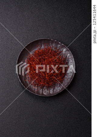 Red thin hot chili threads on a dark background Red thin hot chili threads on a dark background 125411644