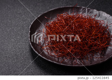 Red thin hot chili threads on a dark background 125411645
