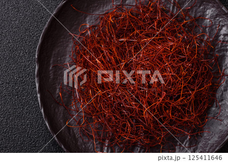 Red thin hot chili threads on a dark background Red thin hot chili threads on a dark background 125411646