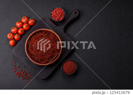 Red thin hot chili threads on a dark background Red thin hot chili threads on a dark background 125411679