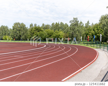 Red treadmill at the stadium with white lines 125411882