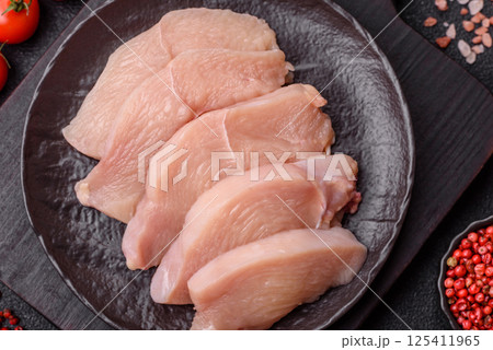Raw chicken or turkey fillet cut into slices with salt, spices and herbs Raw chicken or turkey fillet cut into slices with salt, spices and herbs 125411965