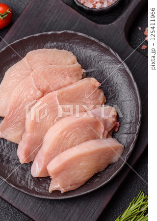 Raw chicken or turkey fillet cut into slices with salt, spices and herbs Raw chicken or turkey fillet cut into slices with salt, spices and herbs 125411966