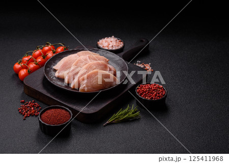 Raw chicken or turkey fillet cut into slices with salt, spices and herbs 125411968