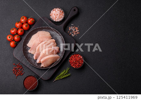 Raw chicken or turkey fillet cut into slices with salt, spices and herbs Raw chicken or turkey fillet cut into slices with salt, spices and herbs 125411969