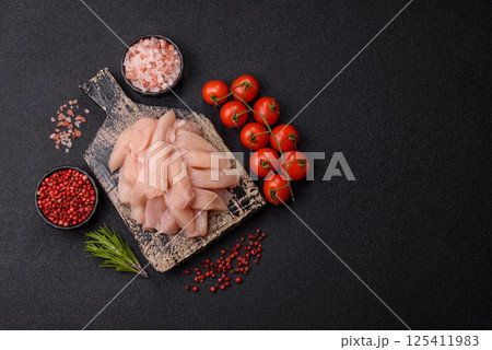Raw chicken or turkey fillet cut into slices with salt, spices and herbs Raw chicken or turkey fillet cut into slices with salt, spices and herbs 125411983