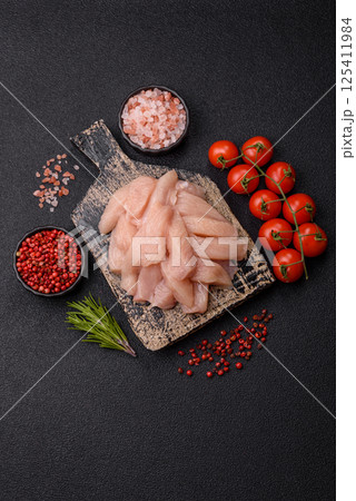 Raw chicken or turkey fillet cut into slices with salt, spices and herbs 125411984