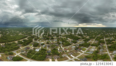 Landscape of dark ominous clouds forming on stormy sky during heavy thunderstorm over rural town area 125413041