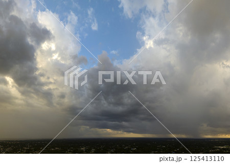 Heavy rain falling down from stormy clouds over rural Florida suburbs. Thunderstorm on dark sky. Moving and changing cloudscape weather 125413110
