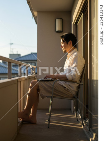 バルコニーで日差しを浴びながら働く日本人男性（ai生成画像） 125413343