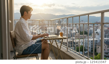 バルコニーで日差しを浴びながら働く日本人男性（ai生成画像） 125413347