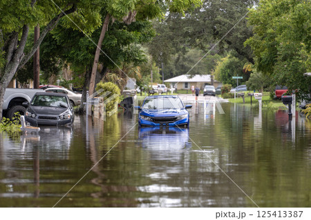 Flooded street with stuck cars after hurricane rainfall in Florida. Aftermath of natural disaster caused by global warming Flooded street with stuck cars after hurricane rainfall in Florida. Aftermath of natural disaster caused by global warming 125413387