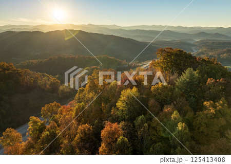 Fall forest on Appalachian mountain hills at sunset with brightly illuminated lush and pine woods. Autumnal landscape of beautiful nature 125413408