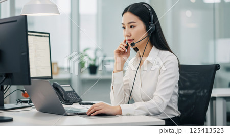 ヘッドセットで通話する日本人女性（ai生成画像） 125413523