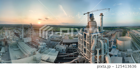Cement plant with high factory structure and tower cranes at industrial production area. Manufacture, global industry and air pollution concept Cement plant with high factory structure and tower cranes at industrial production area. Manufacture, global industry and air pollution concept 125413636