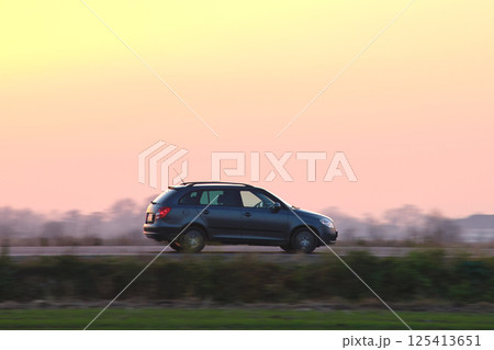 Car driving fast on intercity road at sunset. Highway traffic in evening Car driving fast on intercity road at sunset. Highway traffic in evening 125413651