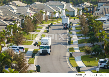 Automated modern garbage collector truck loading waste on Florida town street. Municipal services Automated modern garbage collector truck loading waste on Florida town street. Municipal services 125413697