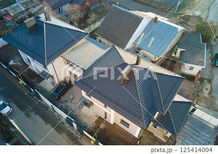 Aerial view of private house with ceramic shingles covered roof top. Investment in real estate concept Aerial view of private house with ceramic shingles covered roof top. Investment in real estate concept 125414004