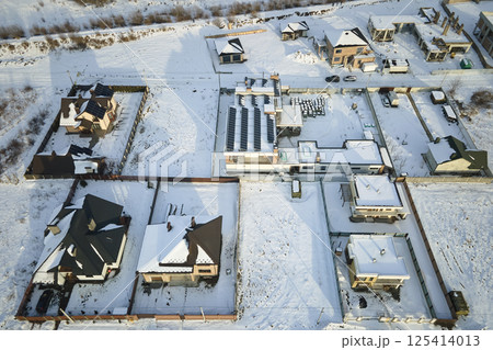 Aerial view of private homes with snow covered roofs in rural suburbs town area in cold winter 125414013