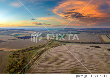 Aerial view of plowed agricultural fields with cultivated fertile soil prepared for planting crops between green woods in fall season 125414014