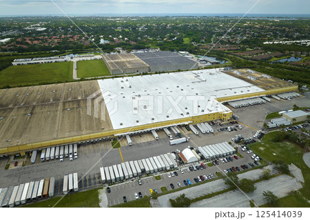 Aerial view of large commercial distribution center with many trucks unloading and uploading retail products for further shipment. Global economy concept Aerial view of large commercial distribution center with many trucks unloading and uploading retail products for further shipment. Global economy concept 125414039