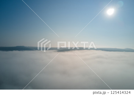 Aerial view from high altitude of earth covered with white puffy cumulus clouds on sunny day 125414324