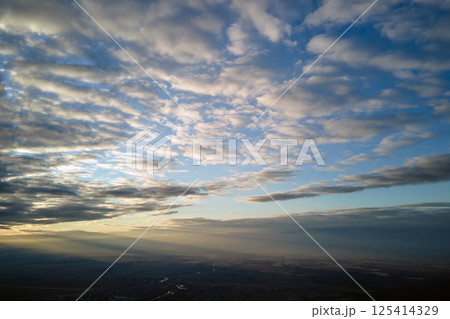 Aerial view at high altitude of dense puffy cumulus clouds forming before rainstorm in evening 125414329