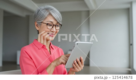 タブレットを使いこなす日本人シニア女性（ai生成画像） 125414678