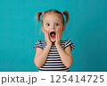 A little girl is making a very surprised face with her mouth open wide 125414725