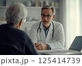 A doctor is engaged in a conversation with a patient in a hospital setting 125414739