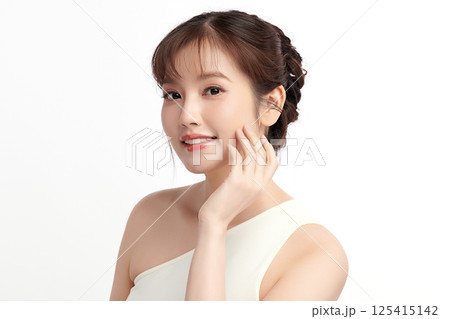 A beautiful young Asian woman with clean, fresh skin against a white background. Skincare, facial treatment, cosmetology, beauty, and spa. An elegant portrait of an Asian woman. 125415142