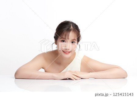 A beautiful young Asian woman with clean, fresh skin against a white background. Skincare, facial treatment, cosmetology, beauty, and spa. An elegant portrait of an Asian woman. 125415143
