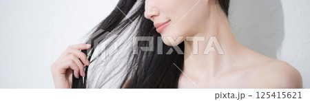 黒髪のロングヘアを触る、美しい若い女性の艶と素肌感が美しいビューティーイメージの横顔のクローズアップ 黒髪のロングヘアを触る、美しい若い女性の艶と素肌感が美しいビューティーイメージの横顔のクローズアップ 125415621