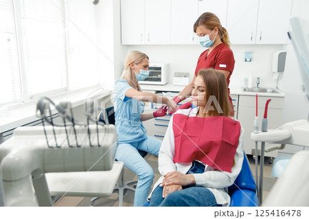 dental procedure, patient lying, dentist checking teeth, smiling patient, hospital office, oral care, dental health 125416478