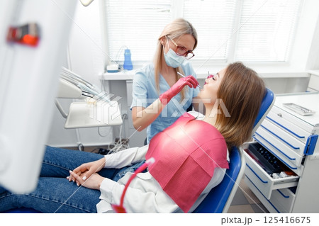 teeth whitening, dentist checking teeth, dental examination, patient's teeth, hospital office, ensuring dental health teeth whitening, dentist checking teeth, dental examination, patient's teeth, hospital office, ensuring dental health 125416675