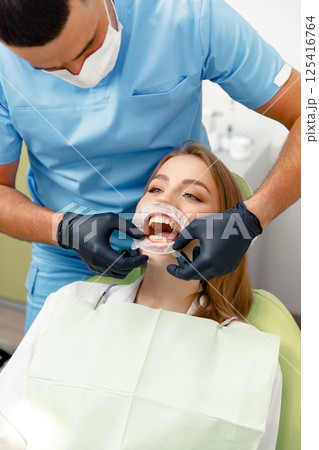 teeth whitening, Dentist starting teeth, whitening procedure, white teeth, receiving teeth cleaning teeth whitening, Dentist starting teeth, whitening procedure, white teeth, receiving teeth cleaning 125416764