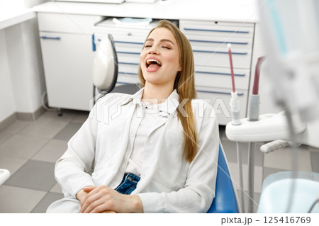smiling dentist patient, dental chair, dentist patient, dentistry clinic, dental procedure, Smiling dentist communicating, dental instruments 125416769