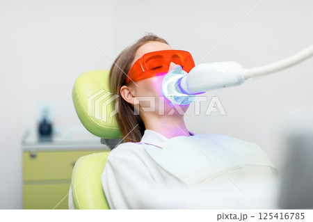 teeth whitening, Dentist starting teeth, whitening procedure, white teeth, receiving teeth cleaning teeth whitening, Dentist starting teeth, whitening procedure, white teeth, receiving teeth cleaning 125416785