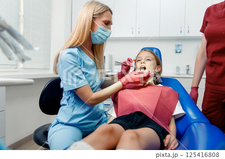 teeth whitening, dentist checking teeth, dental examination, patient's teeth, hospital office, ensuring dental health teeth whitening, dentist checking teeth, dental examination, patient's teeth, hospital office, ensuring dental health 125416808