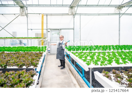 Happy senior Asian man in greenhouse Happy senior Asian man in greenhouse 125417664